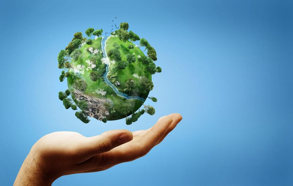 A green and healthy earth held up by a hand.